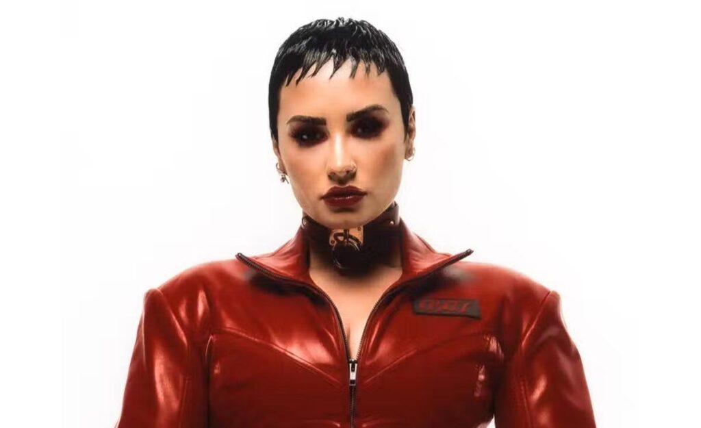 Demi Lovato em Holy Fvck. Artista está de vermelho, com o cabelo curto e olha fixamente para a câmera