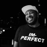 DJ Marky sorrindo, com uma camiseta escrita IM-PERFECT